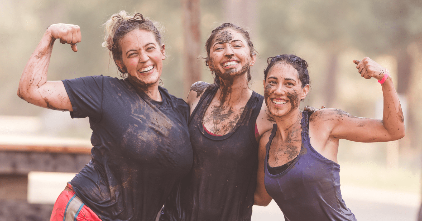 A foto mostra três mulheres felizes após uma maratona desafiadora.